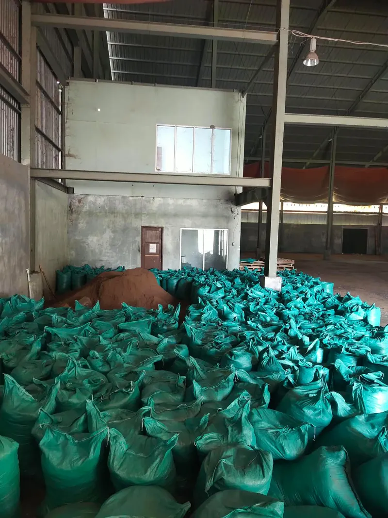 Karung-karung hijau berisi Bungkil Sawit memenuhi lantai gudang Pasangkayu, dengan tumpukan bahan, dinding, dan rangka baja di belakangnya