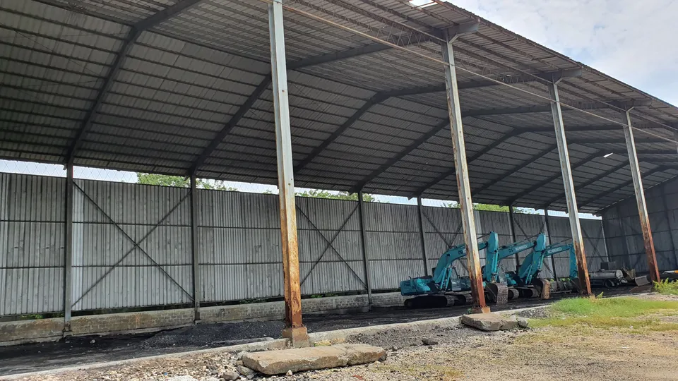 Bangunan gudang beratap baja di Gresik, Jawa Timur, dengan alat berat di bawah atap